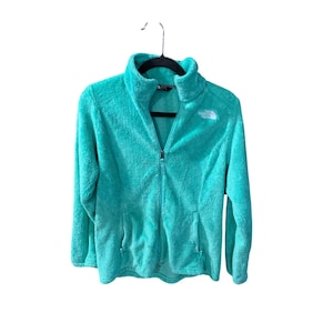 May include: A turquoise blue fleece jacket with a zipper closure and a white logo that says "The North Face".