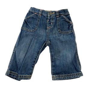 May include: A pair of blue denim jeans with pink stitching and two front pockets.