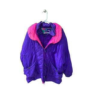 May include: A purple puffer jacket with a pink quilted lining and a contrasting colorful pattern on the inside of the collar.