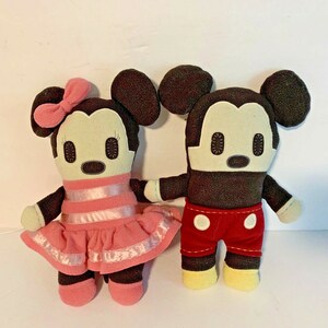 Pu&ograve; includere: Un paio di bambole di peluche di Topolino e Topolina. Topolino indossa pantaloncini rossi con pois bianchi e scarpe gialle. Topolina indossa un vestito rosa con strisce bianche e scarpe rosa.