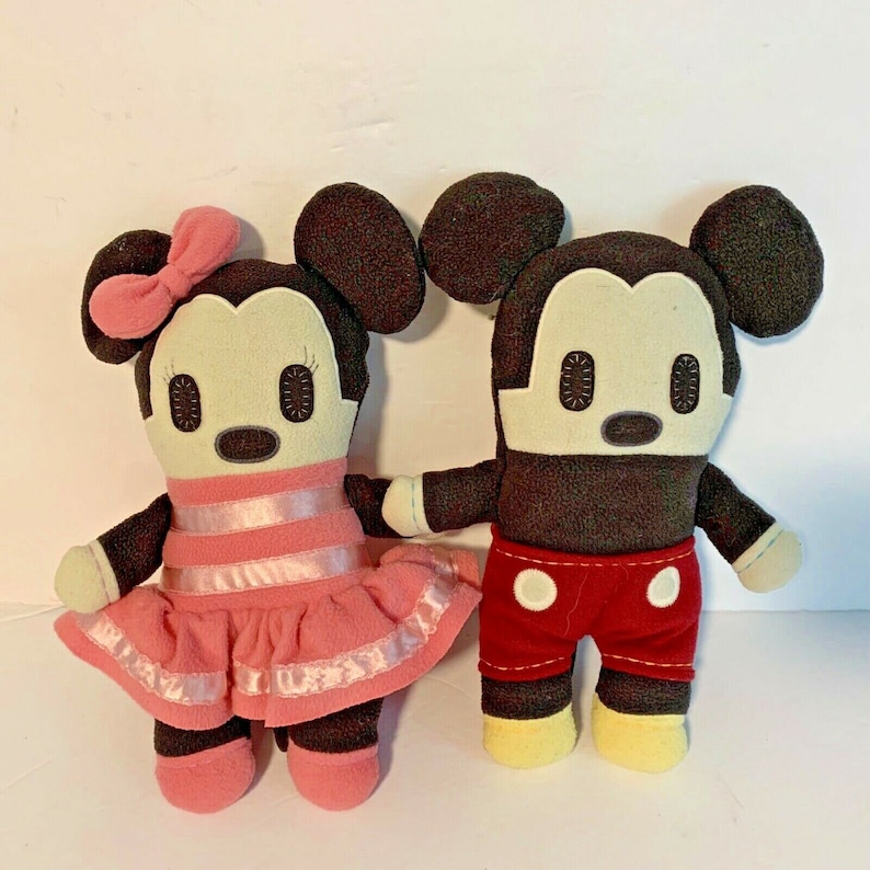 Pu&ograve; includere: Un paio di bambole di peluche di Topolino e Topolina. Topolino indossa pantaloncini rossi con pois bianchi e scarpe gialle. Topolina indossa un vestito rosa con strisce bianche e scarpe rosa.
