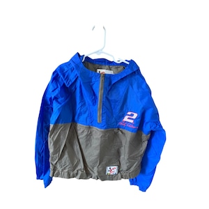 May include: A blue and grey hooded jacket with a zip fastening and the number "2" and "Jeff Gordon" embroidered on the front. The jacket has a small logo on the bottom left side.