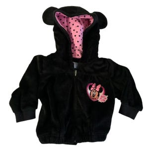 May include: Black fleece hooded jacket with a pink heart pattern lining and a Minnie Mouse applique on the front.