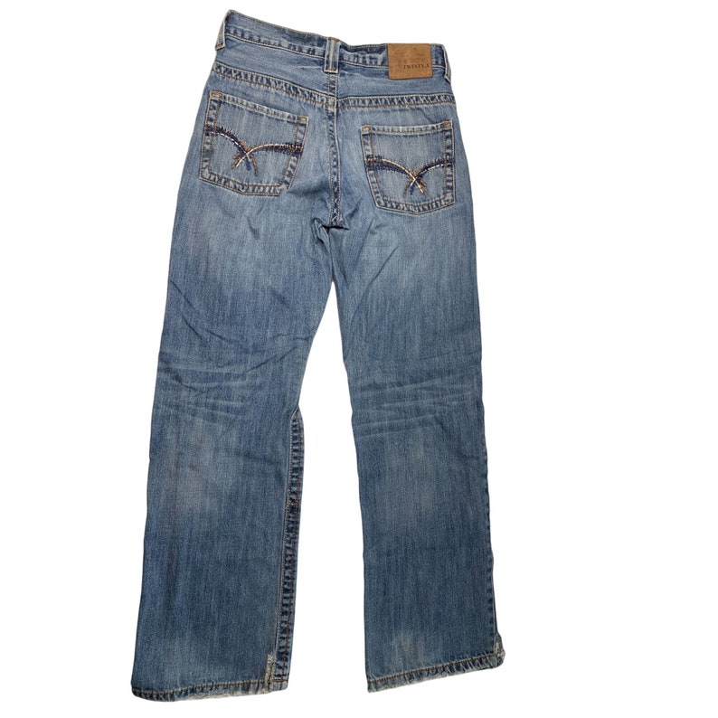May include: A pair of blue denim jeans with a brown leather patch on the back waistband that says "TRU-SPEC".