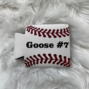 May include: White foam can cooler with a baseball design. The cooler has red stitching and the text "Goose #7" printed on it.