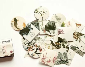 以下が含まれることがあります： 様々なアジア風のデザインが施された装飾用ステッカーのセット。ステッカーは丸型と正方形で、花、魚、風景の画像が描かれています。ステッカーは白地に黒と茶色のインクで印刷されています。
