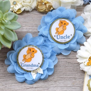 Pu&ograve; includere: Decorazioni per baby shower a forma di fiore azzurro chiaro a tema Simba. Le decorazioni includono una succulenta, rosette e badge con le scritte "Nonna", "Zio", "Mamma" e "Pap&agrave;".