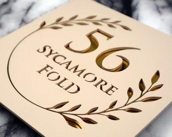 Letrero K Smart / Floral S1 / Letrero decorativo cuadrado para casa en beige, caqui y crema mate, con números de puerta y espejo dorado y flor.