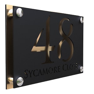 Puede incluir: Placa de número de casa de metal negro con detalles dorados. El número 48 está cortado en el metal y las palabras "SYCAMORE CLOSE" están grabadas debajo.