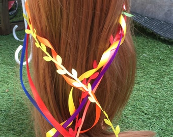 May include: A red, yellow, blue, and purple ribbon headband with white paper leaves. The headband is worn on a red-brown wig.