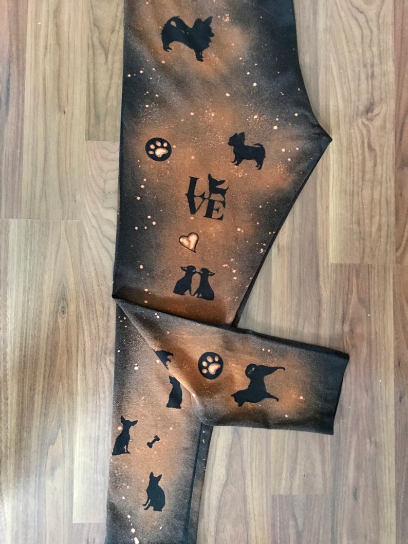 May include: Black leggings with a bleach-splattered design featuring silhouettes of dogs, paw prints, and the word "LOVE".