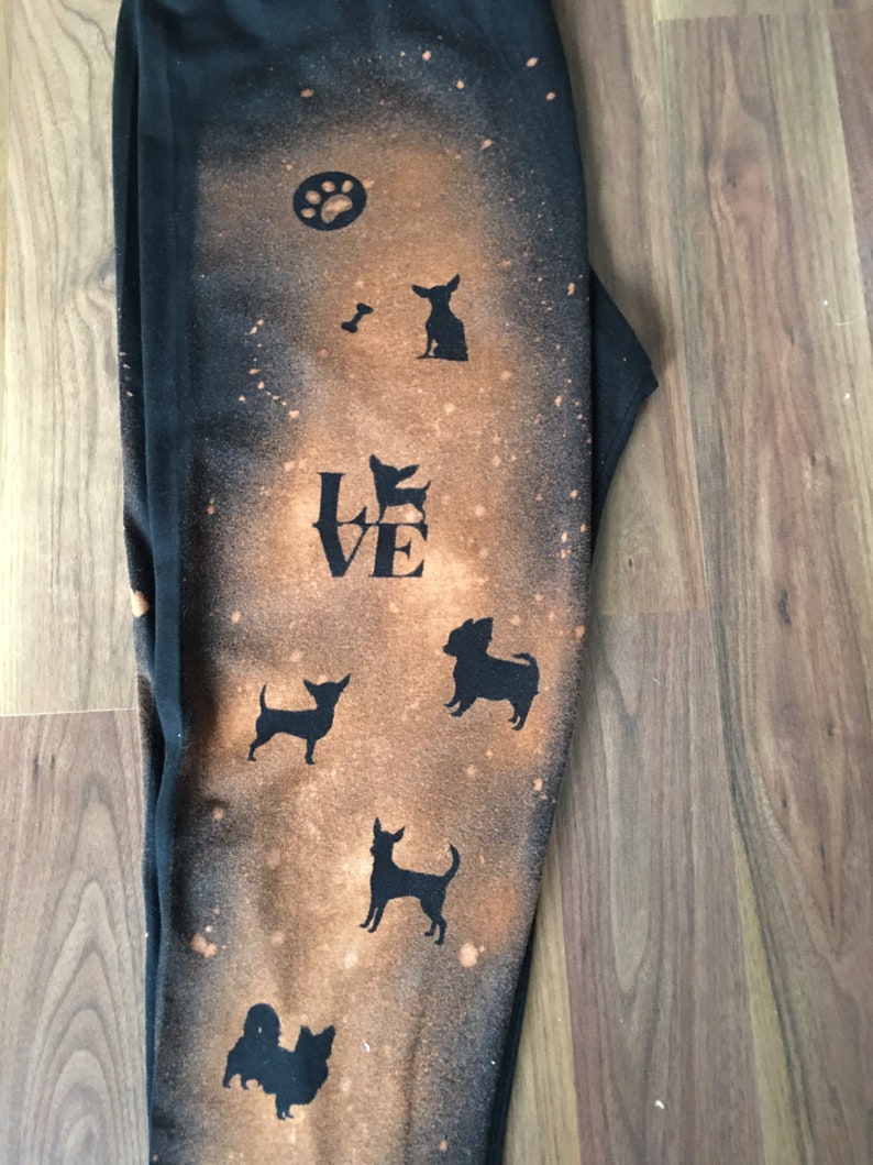 May include: Black sweatpants with a bleach-splattered design featuring a paw print, a bone, the word "LOVE", and multiple silhouettes of small dogs.