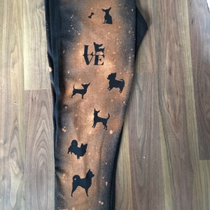 May include: Black leggings with a bleach-splattered design featuring silhouettes of dogs and the word "LOVE".