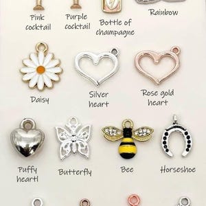 May include: Assortment of charm pendants for jewellery making.  Includes charms shaped like a daisy, heart, butterfly, bee, horseshoe, star, and clover.  Charms are made of silver, rose gold, and gold metal.