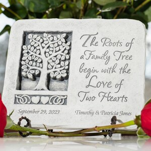 May include: A white stone plaque with a carved tree design and the text "The Roots of a Family Tree begin with the Love of Two Hearts". The plaque also includes the date "September 29, 2023" and the names "Timothy & Patricia Jones".