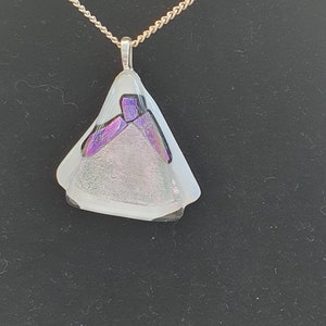 Mosaic dichroic glass fused onto white bullseye base with a tack fuse top of clear creating a textured finish.