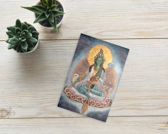 May include: A painting of a green deity sitting on a lotus flower. The deity has a golden halo and is surrounded by a blue and purple background.