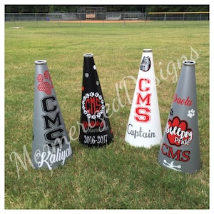 May include: Four gray, white, and black megaphones with red and black lettering. The megaphones are decorated with the text "CMS", "Captain", "Bulldog Pride", and "Kailtyah".