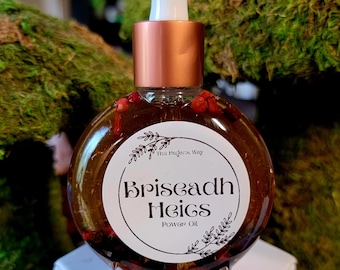 May include: A round glass bottle filled with amber liquid and red peppercorns, topped with a copper-coloured dropper cap. A white circular label features the text "The Pagans Way", "Briseadh Heigs", and "Power Oil" in black lettering.