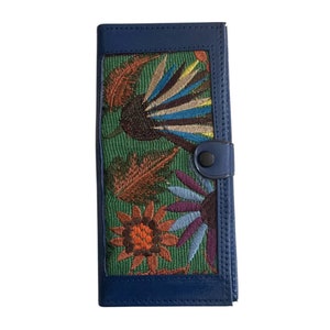 May include: A blue leather wallet with a green fabric insert featuring colorful embroidered flowers and leaves.