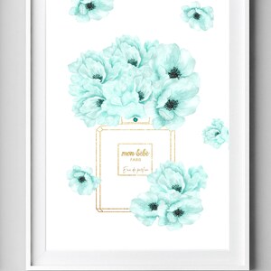 May include: A white framed print with a watercolor illustration of a perfume bottle with a gold lid and a bouquet of light blue flowers. The bottle has the text "mon b&eacute;b&eacute; PARIS Eau de parfum" on the label.