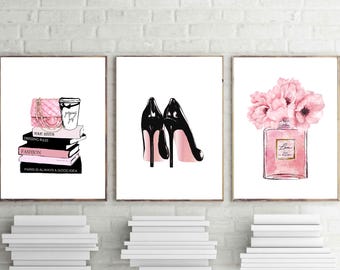May include: Three framed art prints with fashion-themed illustrations. One features a pink purse, coffee cup, and books with text. Another shows black high heels. The third depicts a perfume bottle with pink flowers.