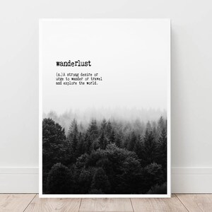 May include: Black and white print with the word "wanderlust" defined as a strong desire to travel and explore the world. The print features a foggy forest scene.