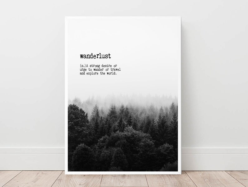 May include: Black and white print with the word "wanderlust" defined as a strong desire to travel and explore the world. The print features a foggy forest scene.