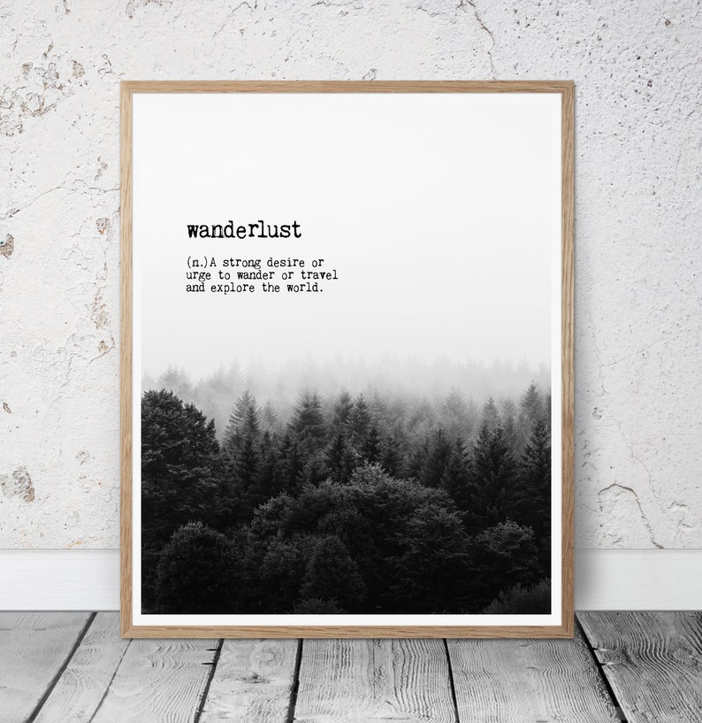 May include: Black and white print of a forest with the definition of the word "wanderlust" printed above the image. The definition reads: "(n.) A strong desire or urge to wander or travel and explore the world."