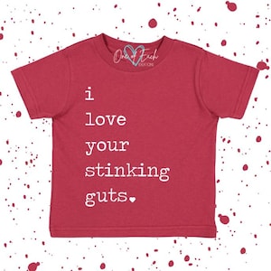 May include: Red short-sleeved t-shirt with the text "I love your stinking guts." in white. The shirt has a crew neck and a small logo at the top. The background has a pattern of white and red dots.