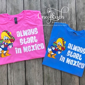 May include: Two t-shirts with a cartoon duck wearing a sombrero and holding maracas. The text on the shirts reads "Always start in Mexico".