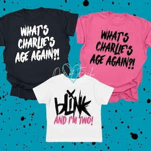 May include: Three t-shirts: black, pink, and white. The black and pink shirts have the text "WHAT'S CHARLIE'S AGE AGAIN?!" in white and black, respectively. The white shirt says "BLINK AND I'M TWO!" in black and pink.