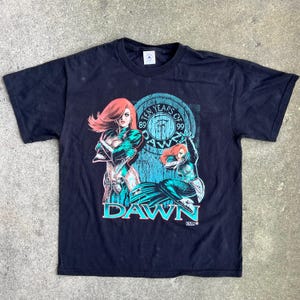 May include: Black t-shirt with a graphic print of two women in green and blue costumes. The graphic includes the text "Ten Years of Dawn 89-99".