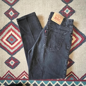May include: Black denim jeans with a Levi's brand label. The jeans have a high waist and a straight leg.