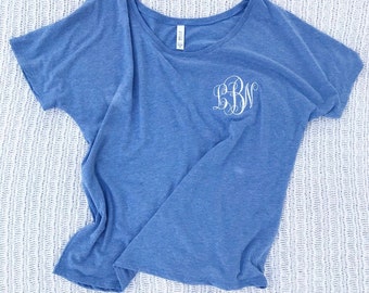 Puede incluir: Una camiseta azul con un monograma blanco en la parte delantera. El monograma son las letras "BBN".