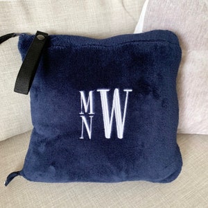 K&ouml;nnte beinhalten: Ein dunkelblaues Fleece-Wurfkissen mit einem wei&szlig;en gestickten Monogramm "M N W".