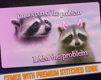 May include: A rectangular mousepad featuring two raccoon illustrations. One raccoon has a neutral expression, while the other has pink devil horns and a mischievous look. Text reads "I'm not part of the problem" and "I AM the problem."