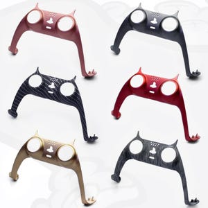 Op de afbeelding: Zes verschillende gekleurde auto-dashboardbekledingsstukken met een kattenachtig ontwerp. De bekledingsstukken zijn gemaakt van plastic en hebben verschillende afwerkingen, waaronder carbonfiber, goud en rood.