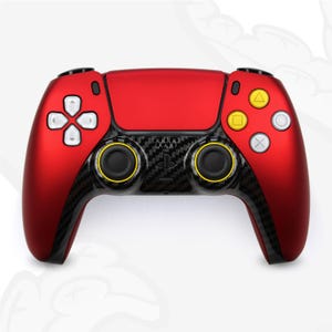 Peut inclure: Une manette de jeu PlayStation 5 rouge et noire avec des boutons jaunes. La manette a un design en fibre de carbone sur les poignées.