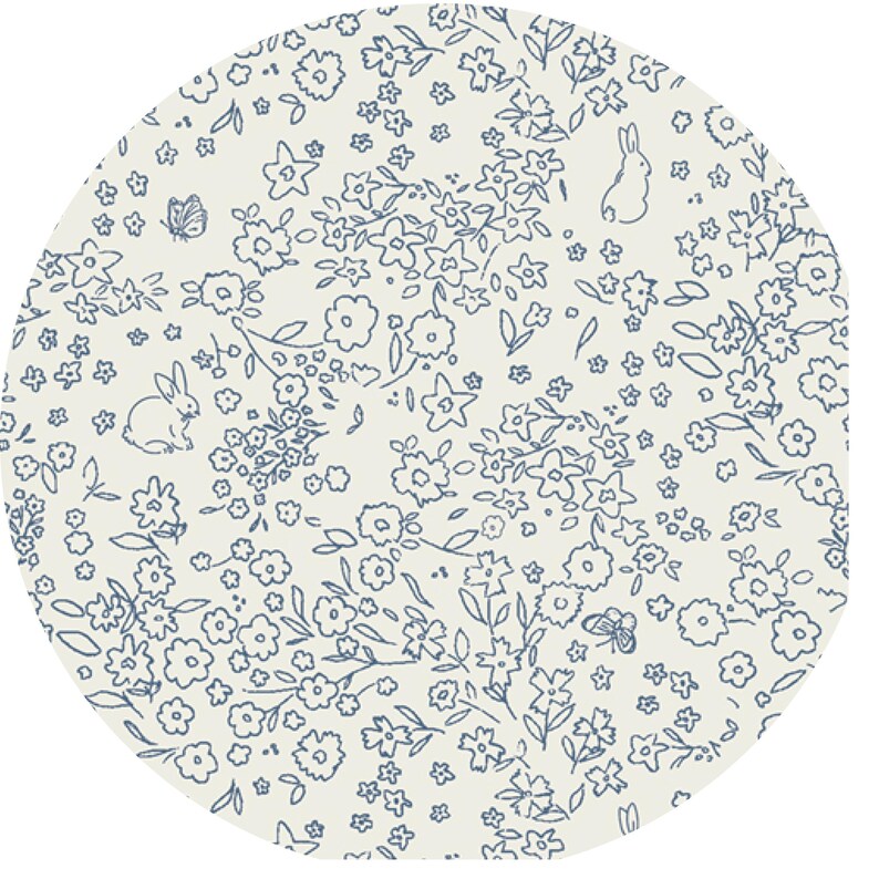 以下が含まれることがあります： 小さな花、葉、ウサギが描かれた青い花柄の白い生地。生地は微妙な質感で円形です。