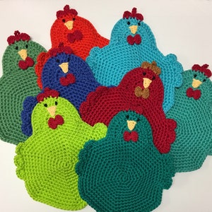 May include: Eight crocheted chicken pot holders in various colors, including green, red, blue, and teal. Each pot holder features a crocheted chicken design with a beak, eyes, and a red bow.