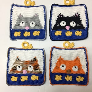 May include: Four crocheted cat-themed pot holders with a fishbone design. Each pot holder features a different colored cat with white eyes and a pink nose. The cats are surrounded by yellow fish.