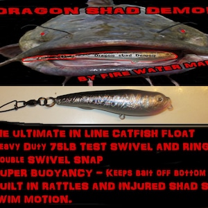 May include: A silver and black catfish float with the text "Dragon Shad Demon" and "By Fire Water Marine". The float has a swivel snap and ring, designed for heavy-duty use. The text also mentions super buoyancy and injured shad swim motion.
