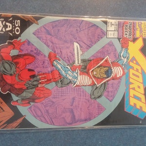 May include: A comic book cover for X-Force featuring two figures in action. One figure is in red and black, the other in red, white, and blue. The cover includes the text "DEADPOOL'S BACK!" and "THE BLOOD HUNTERS!"