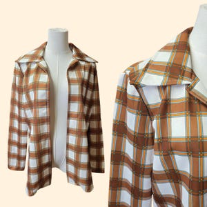 May include: A vintage open-front jacket in a brown, white, and orange plaid pattern. The jacket features a wide collar and long sleeves. The fabric has a retro aesthetic, perfect for a unique style.