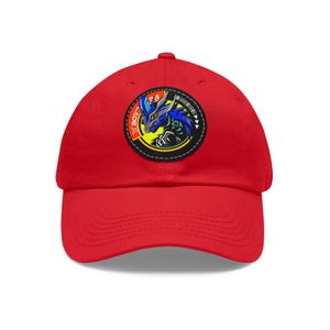 May include: Red baseball cap with a blue and black embroidered patch featuring a dragon-like creature with the text "GADE X" and the number "33" on the front.