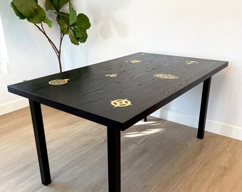 Black dining table with brass inlays