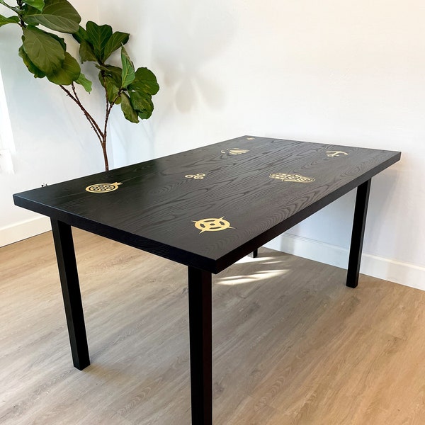 Black dining table with brass inlays