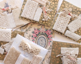 Puede incluir: Surtido de encajes y telas vintage. El encaje presenta varios tonos crema y beige, con diferentes patrones y texturas. Algunos paquetes están envueltos con papel decorativo. La estética general es vintage y artesanal.