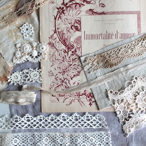 Può includere: Un assortimento di pizzi e ritagli di tessuto vintage in tonalità neutre. È presente anche un foglio di carta invecchiata con illustrazioni floreali e il testo "Immortalité d'amour". L'immagine evoca un senso di nostalgia e artigianato.
